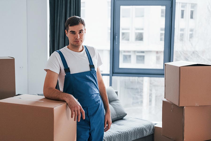 young-male-mover-in-blue-uniform-works-indoors-in-BU9HHGP